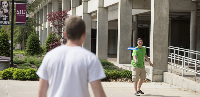 Students on Campus throwing Frisbee